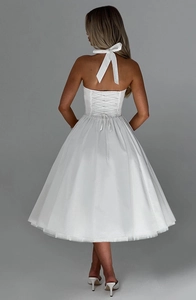 Detail of white halter dress featuring elegant back lace-up ties and full puffy skirt