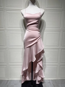 Detail of light pink satin evening dress featuring side pleats and ruffled asymmetric hem