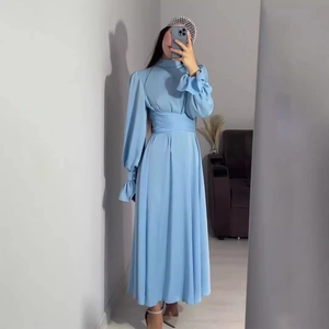 Détail de la robe en satin bleu clair avec manches lanternes et poignets à volants élégants