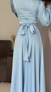 Détail du dos d'une robe en satin bleu clair avec un grand nœud et une taille élégante