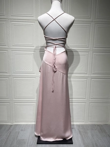 Detail of pink satin evening dress featuring a criss-cross backless design on a mannequin