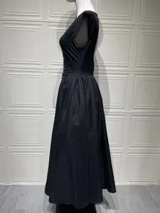 Side view of a black sleeveless A-line midi dress with smooth satin finish on a mannequin