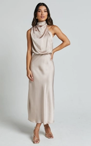 Detail eines eleganten Satin-Neckholder-Kleides mit glatter Textur in Champagner