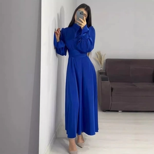 Détail de robe longue en satin bleu roi avec manches bouffantes et taille haute cintrée