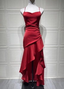 Detail of red satin backless dress featuring elegant ruffles and irregular hemline