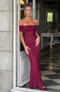 Détail d'une robe de soirée élégante en dentelle rouge vin avec coupe sirène et encolure Bardot