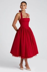 Macro view of a red halter dress showing pleated puff skirt and layered mesh fabric texture