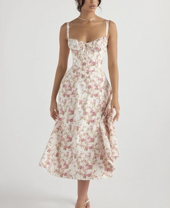 Detail van witte bloemenjurk met vetersluiting bij de hals en roze rozenpatroon