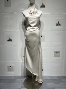 Detail of elegant cream satin dress showing cow neck and draped pleats on hip
