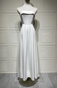Détail d'une robe de soirée blanche sans bretelles élégante avec décolleté plié et coupe A-line