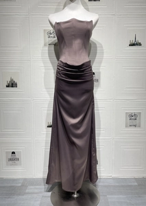 Macro detail of the elegant side ruching and draped satin fabric on the mauve gown
