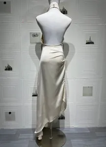 Detail of champagne satin backless dress featuring side slit and elegant ruching