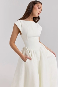 Detail of elegant white sleeveless dress featuring side pockets and textured pleats