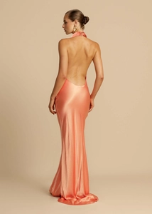Detail of elegant coral satin halter dress showing backless cut and silky texture