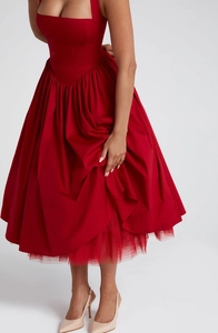 Detail of red corset style dress showing the fitted bodice and voluminous tulle skirt