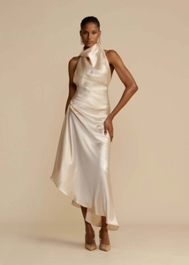 Detailed view of champagne satin dress with elegant draped halter neckline and silk texture