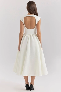Detail of the elegant white backless A-line midi dress with a circular cutout design