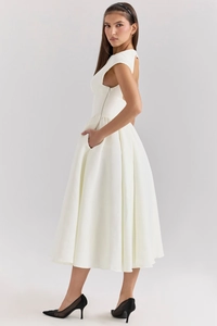Detailed side view of white sleeveless midi dress featuring hidden pockets and A-line skirt