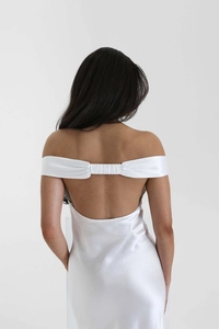 Close-up of the open-back detail and ruched shoulder straps on white satin evening gown