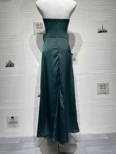 Detail view of dark green satin dress showing back invisible zipper and fitted waist line