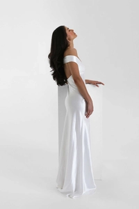 Detail of elegant white satin finish on a slim fit fishtail evening dress with backless cut
