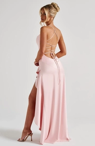 Detail view of pink satin backless dress featuring elegant crisscross straps and ruffles