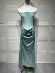 Close-up of mint green satin evening dress featuring structured corset and wave neckline
