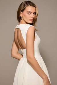 Detail of elegant open back cutout and pleated waist on white sleeveless midi dress