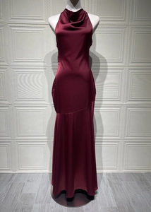 Detail of burgundy satin fishtail evening dress featuring cowl neck and glossy fabric