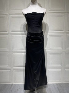 Detail view of the elegant layered horizontal pleats on the black satin strapless gown