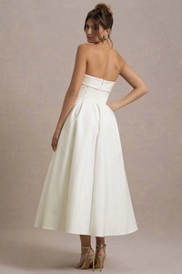 Détail d'une élégante robe midi en satin blanc sans bretelles avec coupe trapèze et zip