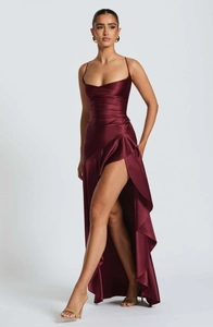 Detail of burgundy satin dress showing thin straps and ruffled slit hemline