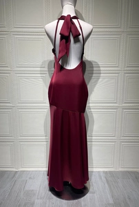 Detailed back view of a burgundy satin fishtail gown with a large bow and open back design