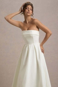 Détail d'une robe de soirée bustier blanche en satin avec des plis à la taille