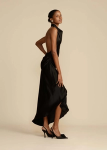 Detail of elegant black satin halter dress featuring a sexy backless design and side slit