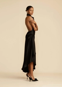 Detail of elegant black satin backless dress with a side slit and sophisticated draping