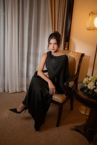 Vue détaillée d'une robe de soirée en satin noir avec un élégant drapé à une épaule