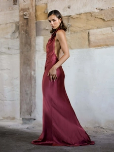 Close-up of elegant burgundy satin backless maxi dress with a halter neck and high shine