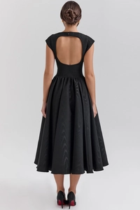 Detail view of a black backless midi dress with elegant pleats and cut-out design