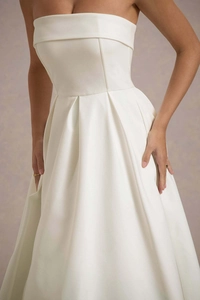 Détail de la robe bustier ivoire élégante avec plis en satin et poches invisibles
