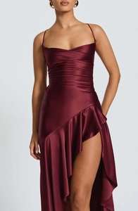 Detail of burgundy satin dress showing delicate ruffles and high-slit asymmetric hem