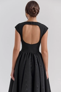 Detail of elegant backless design with double button closure on a black midi dress