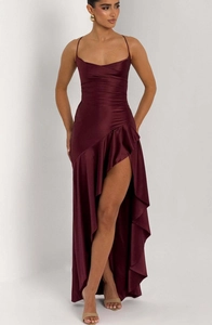 Detail of burgundy satin dress showing delicate ruffles and high-slit asymmetric hemline