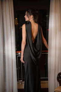 Détail d'une robe de soirée dos nu en satin noir élégant avec drapé fluide et texture soie