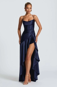 Detailed close-up of navy blue satin dress showing spaghetti straps and ruffled hemline