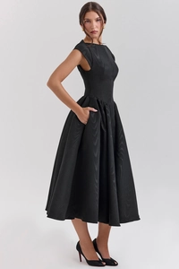 Detail shot of sleek black satin midi dress featuring functional side seam pockets