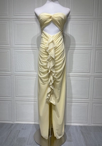 Detail of light yellow strapless dress featuring waist cut-out and elegant ruched ruffles