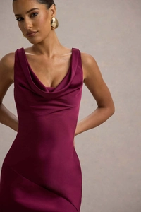 Dettaglio dell'elegante abito in raso rosso vino con un sofisticato scollo a cappuccio
