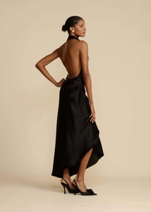 Detail of elegant black satin backless evening gown with side slit and draped silhouette