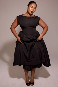 Detail of elegant black backless midi dress with fine ribbed texture and pleated flared skirt